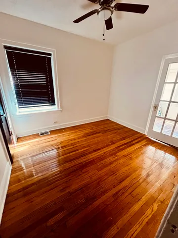 a view of empty room with window and wooden floor