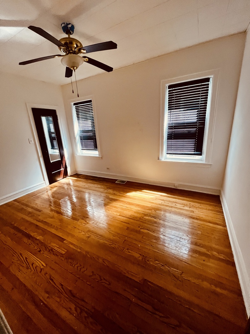 8236 South Sangamon Street, Unit 1 Chicago, IL 60620 - Photo 2 of 12 a view of room with hardwood floor and a ceiling fan