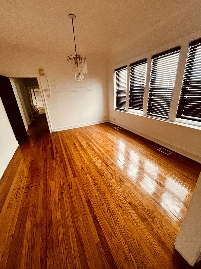 8236 South Sangamon Street, Unit 1 Chicago, IL 60620 - Photo 3 of 12 a view of an empty room with wooden floor and windows