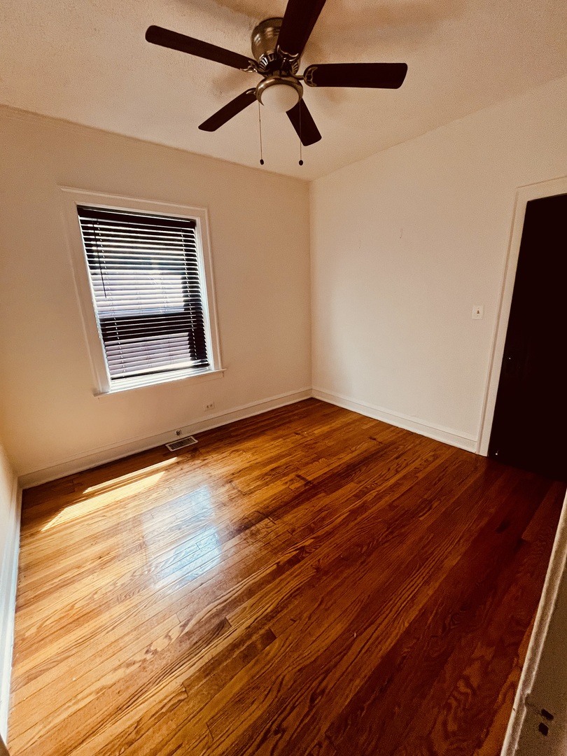 8236 South Sangamon Street, Unit 1 Chicago, IL 60620 - Photo 5 of 12 a view of an empty room with a window and wooden floor