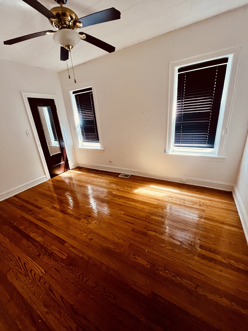 8236 South Sangamon Street, Unit 1 Chicago, IL 60620 - Photo 9 of 12 a view of an empty room with wooden floor and a window