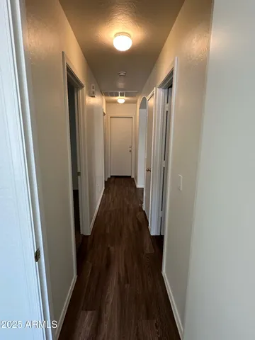 a view of a hallway with wooden floor