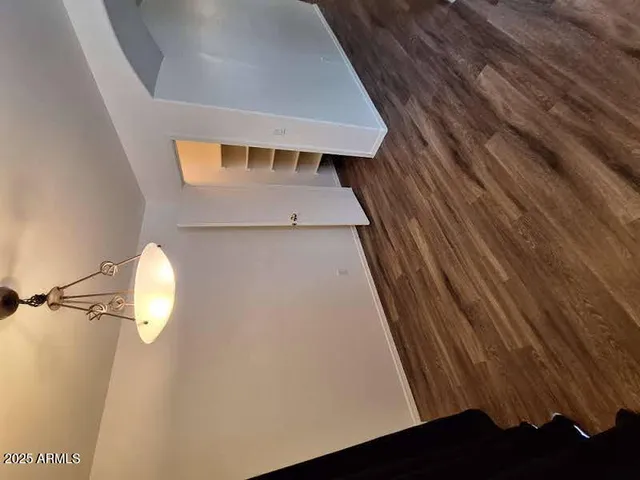 a kitchen with granite countertop a refrigerator a sink a stove a microwave a counter space and wooden floor