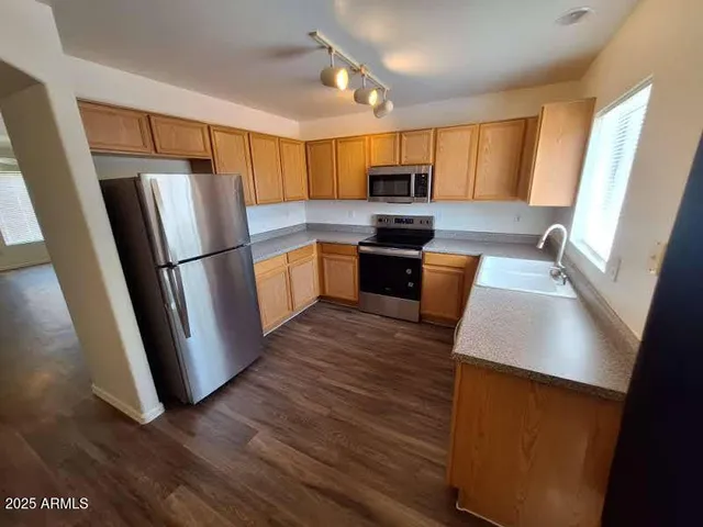 a kitchen with wooden floors and stainless steel appliances