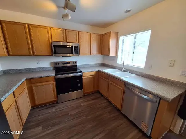an empty room with wooden floor and a ceiling fan