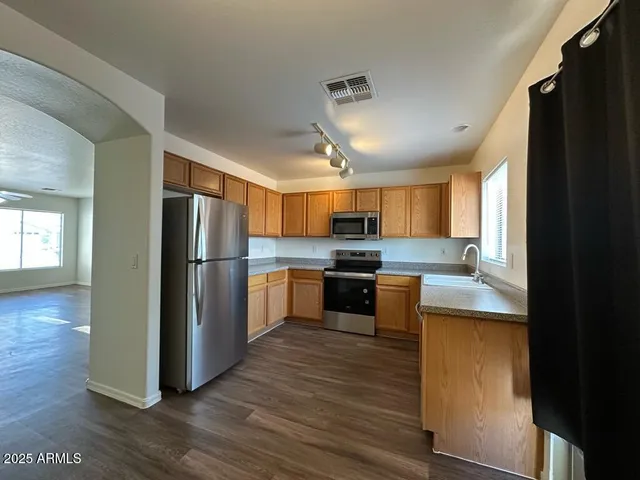 a kitchen with stainless steel appliances a refrigerator and a stove top oven