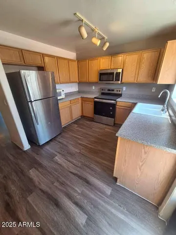 a kitchen with granite countertop a refrigerator and a stove top oven