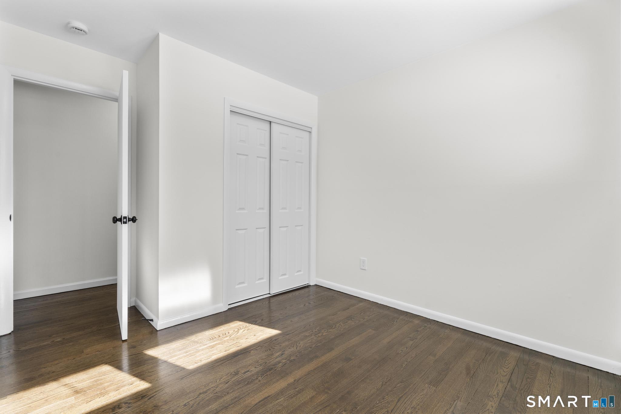 122 Lakeside Drive Ridgefield, CT 06877 - Photo 15 of 29 an empty room with wooden floor