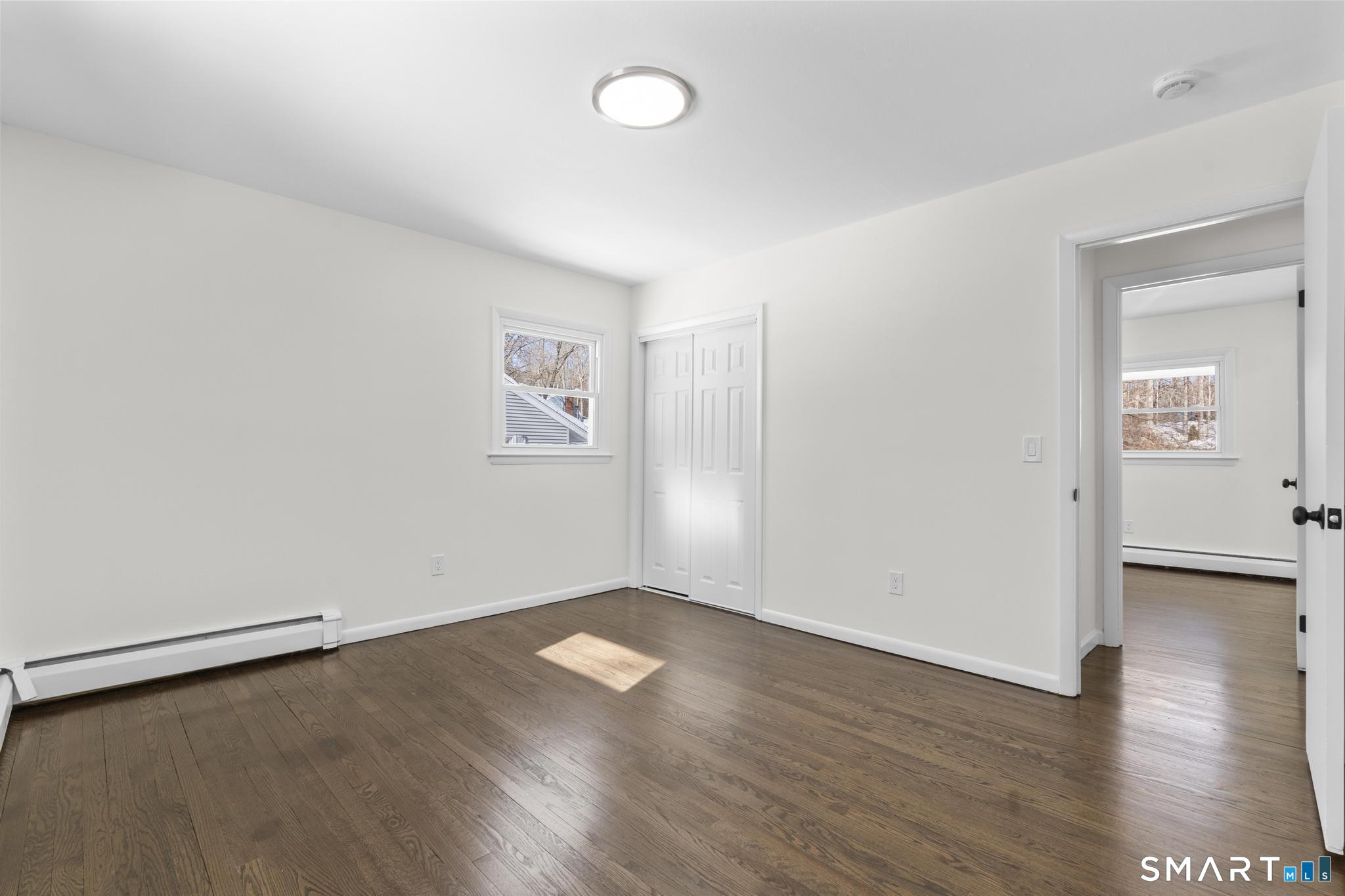 122 Lakeside Drive Ridgefield, CT 06877 - Photo 16 of 29 an empty room with wooden floor and windows