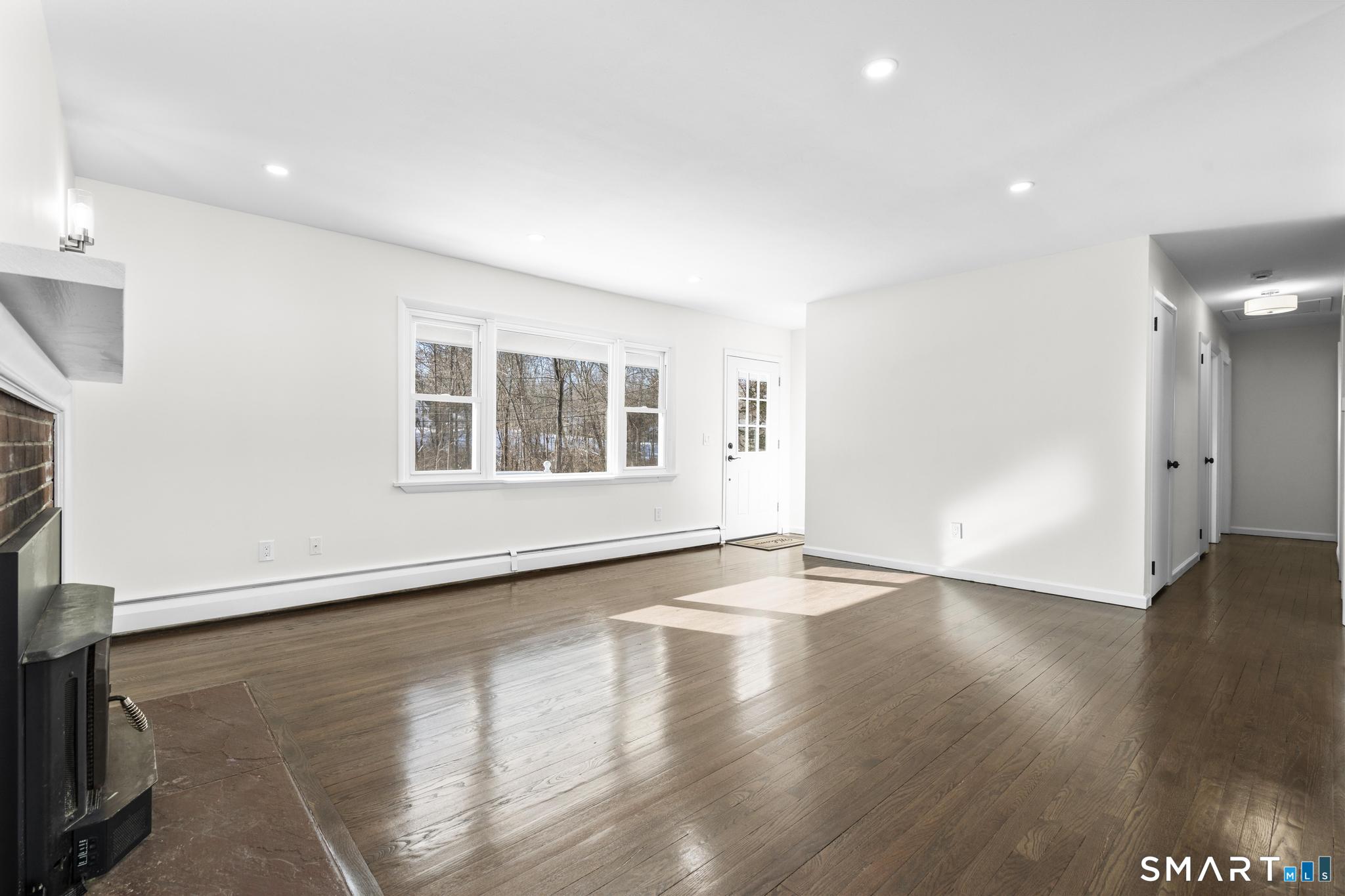 122 Lakeside Drive Ridgefield, CT 06877 - Photo 3 of 29 a view of an empty room with wooden floor and a window