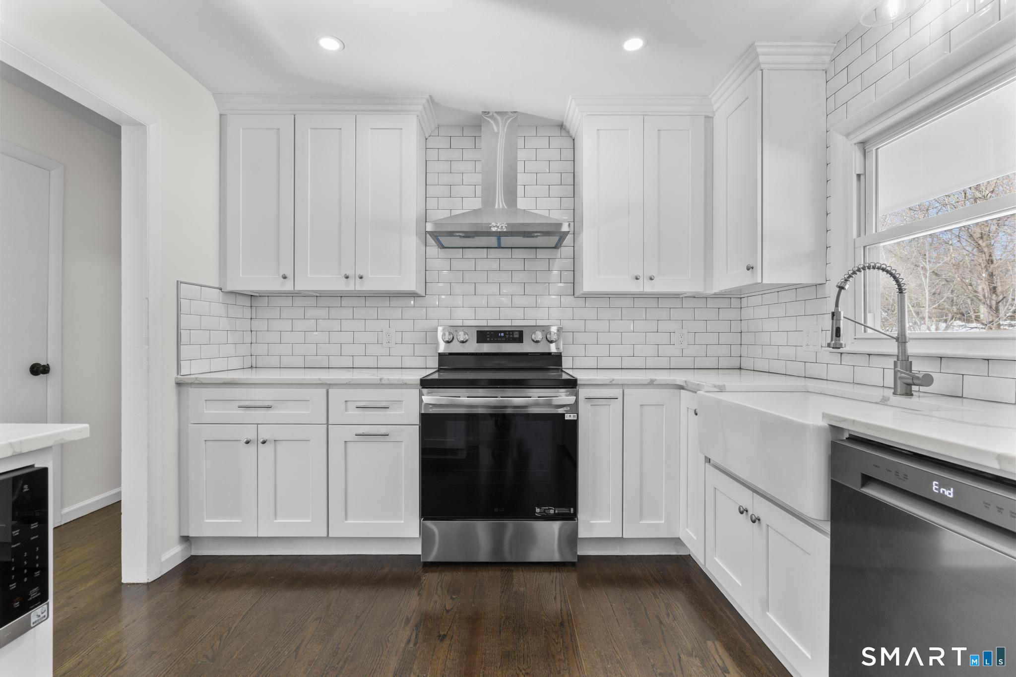 122 Lakeside Drive Ridgefield, CT 06877 - Photo 9 of 29 a kitchen with stainless steel appliances granite countertop a stove and white cabinets