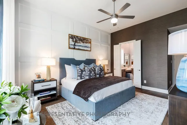 a bedroom with a bed a couch and a potted plant