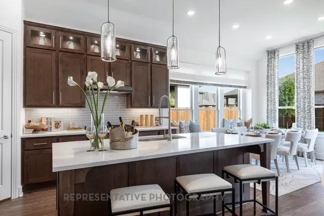a kitchen with cabinets a sink and chairs