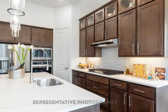 a kitchen with stainless steel appliances a sink a stove and cabinets