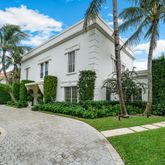 a front view of a house with a garden and yard