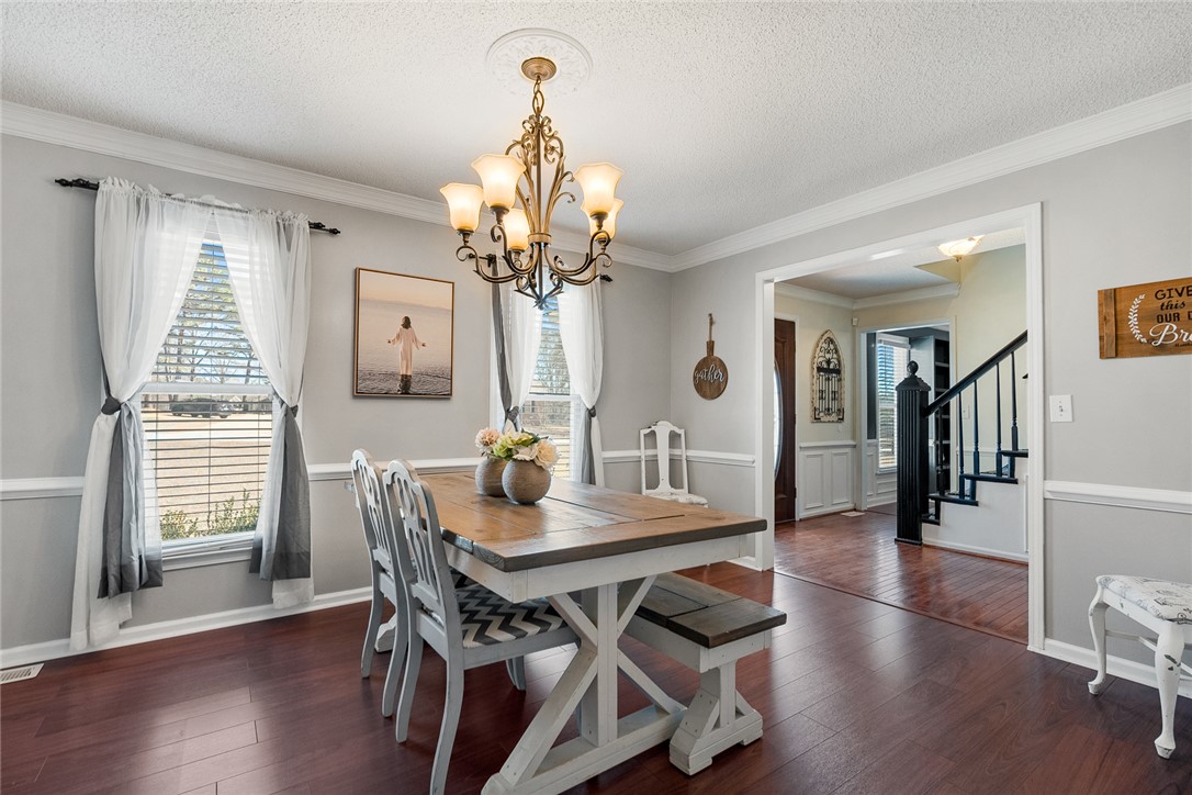 112 C-10-220 Anderson, SC 29621 - Photo 7 of 45 This inviting dining area features elegant hardwood flooring, crown molding, and a charming chandelier.