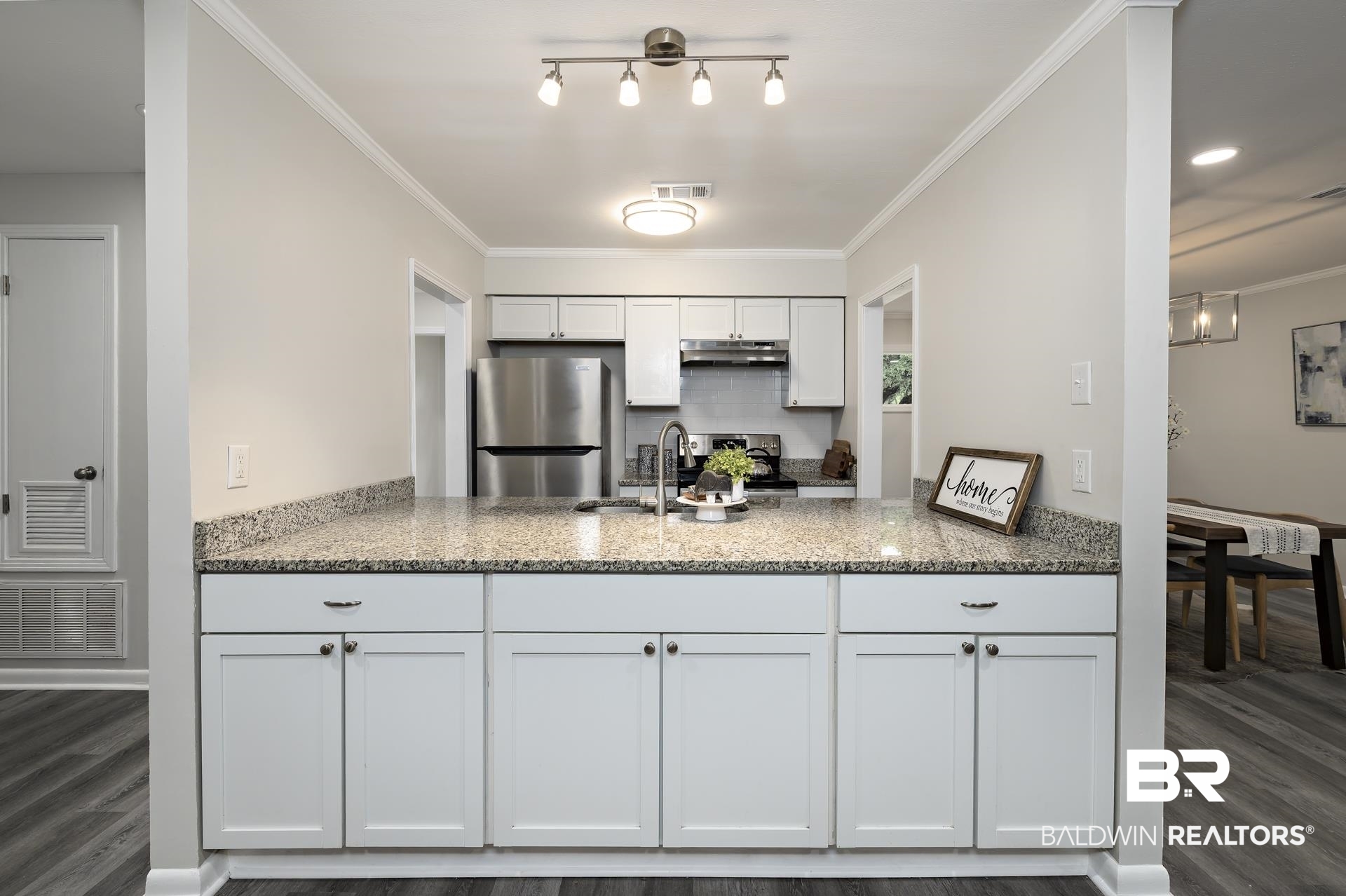 5922 Sunnyside Drive Mobile, AL 36619 - Photo 41 of 51 Kitchen featuring appliances with stainless steel finishes, a peninsula, under cabinet range hood, light stone countertops, and white cabinets