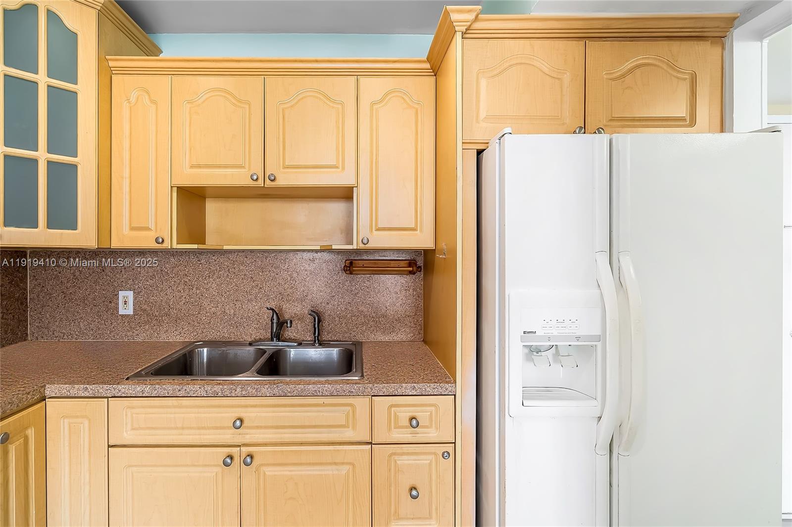 2025 Northeast 164th Street, Unit 907 North Miami Beach, FL 33162 - Photo 14 of 33 a kitchen with a refrigerator and cabinets
