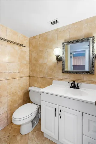 a bathroom with a sink a toilet and mirror