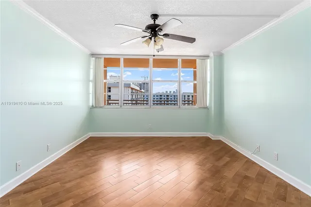 an empty room with a window and a ceiling fan
