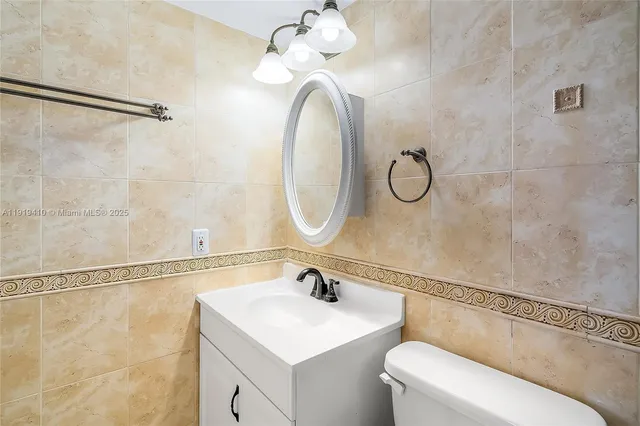 a bathroom with a toilet a sink and a mirror