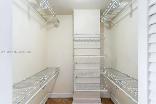 a view of walk in closet with empty racks