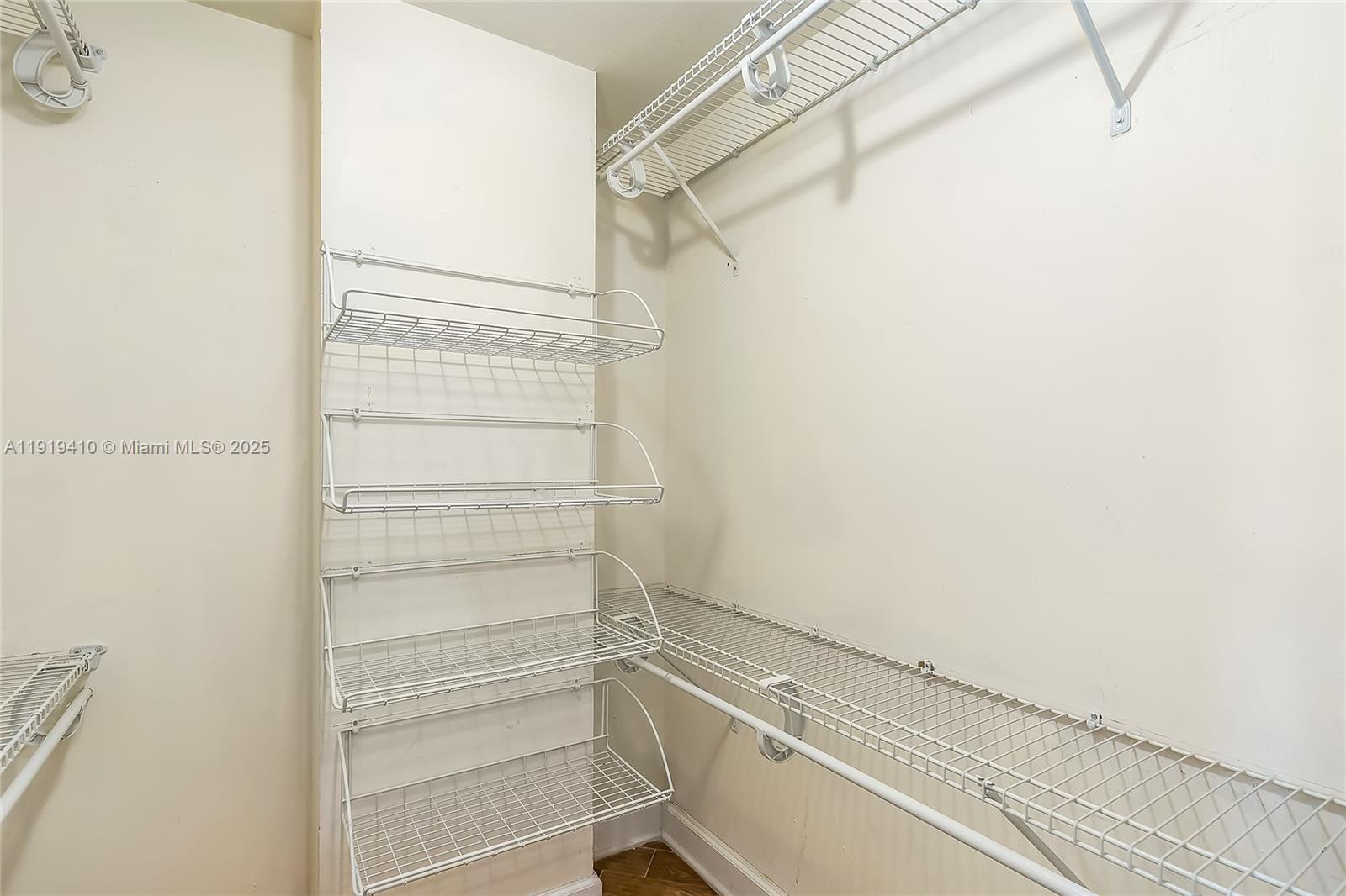 2025 Northeast 164th Street, Unit 907 North Miami Beach, FL 33162 - Photo 29 of 33 a view of walk in closet with empty racks