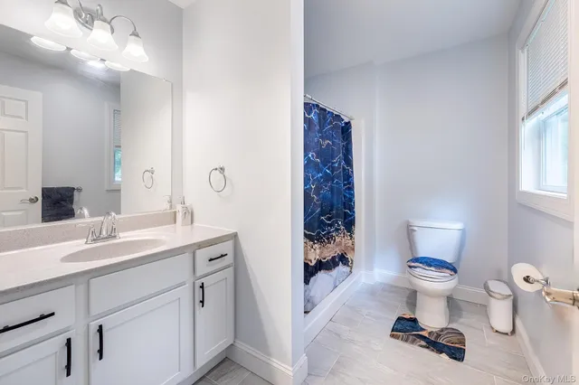 a bathroom with a sink toilet and a mirror