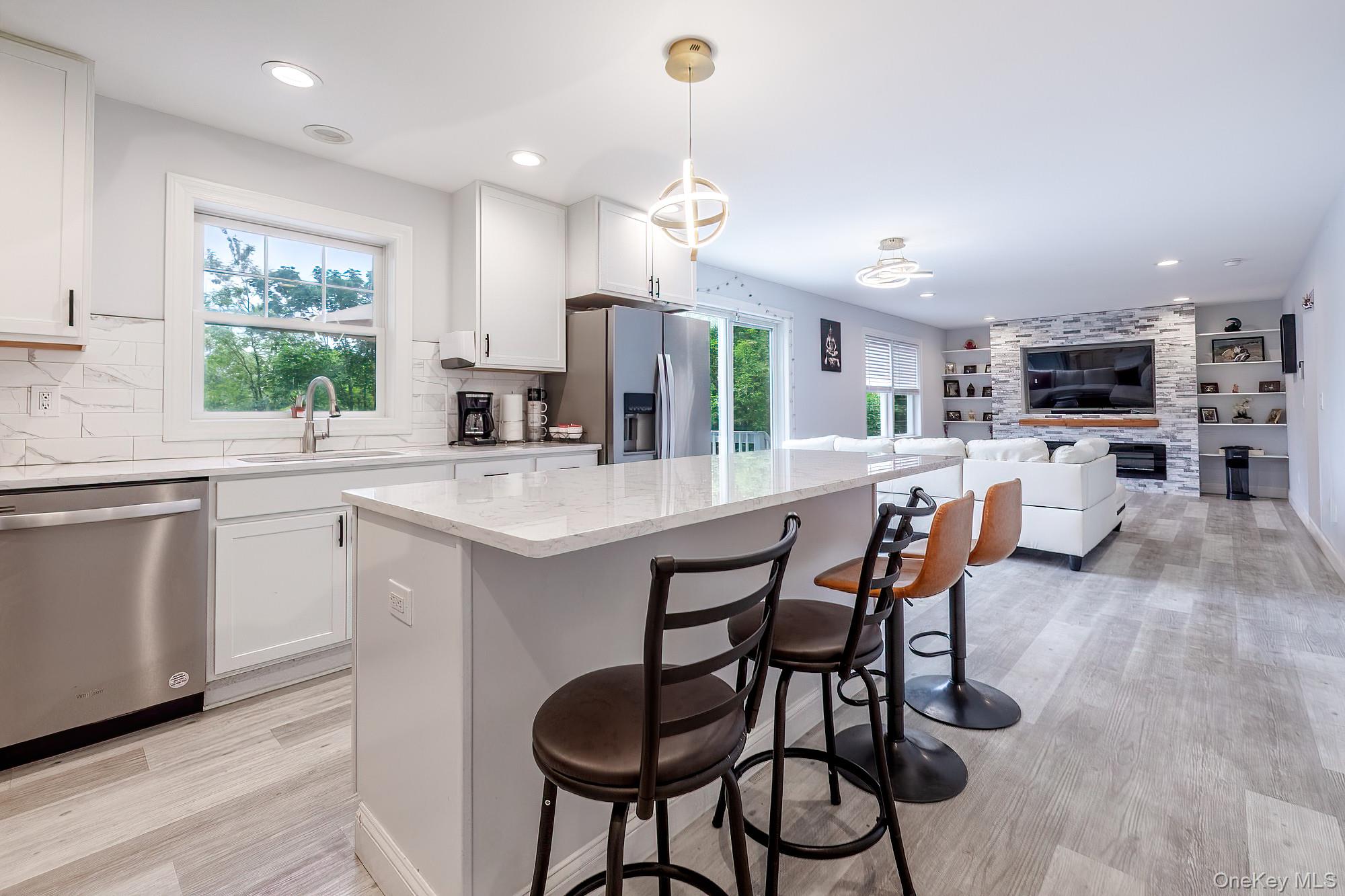 5 Teramar Way White Plains, NY 10607 - Photo 5 of 39 a kitchen with kitchen island a dining table chairs and white appliances
