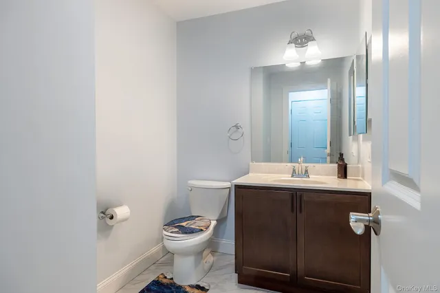 a bathroom with a toilet a sink and mirror