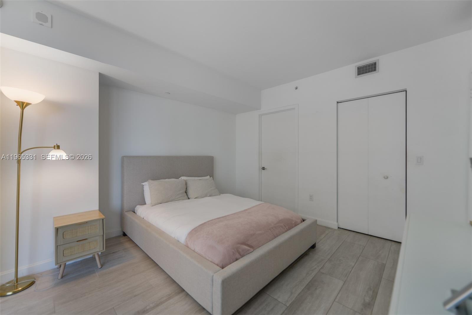 45 Southwest 9th Street, Unit 1107 Miami, FL 33130 - Photo 17 of 50 a bedroom with a bed and a night stand
