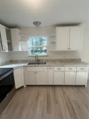 a kitchen with granite countertop white cabinets and white appliances