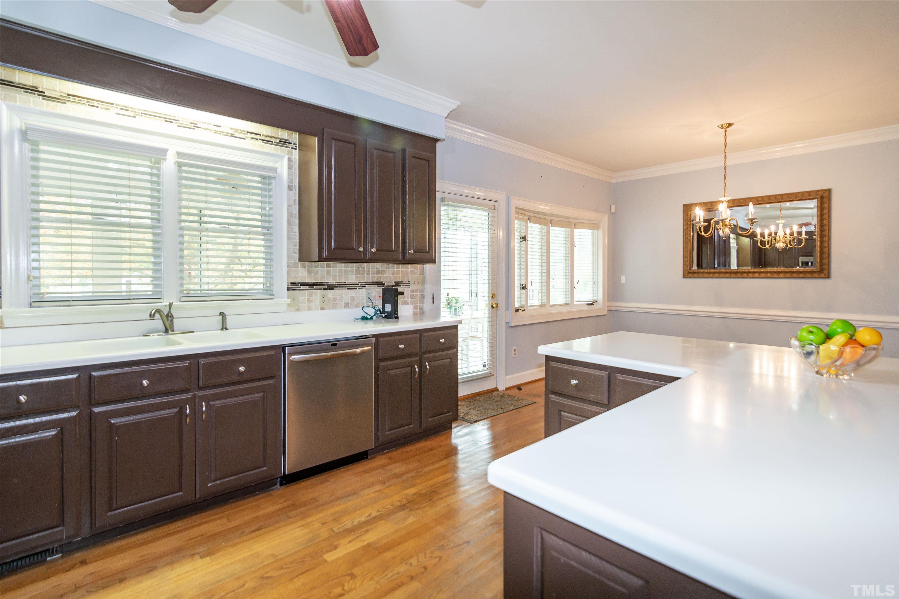 7020 Zebulon Road Wake Forest, NC 27587 - Photo 11 of 45 a large kitchen with stainless steel appliances a stove a sink a center island and a window