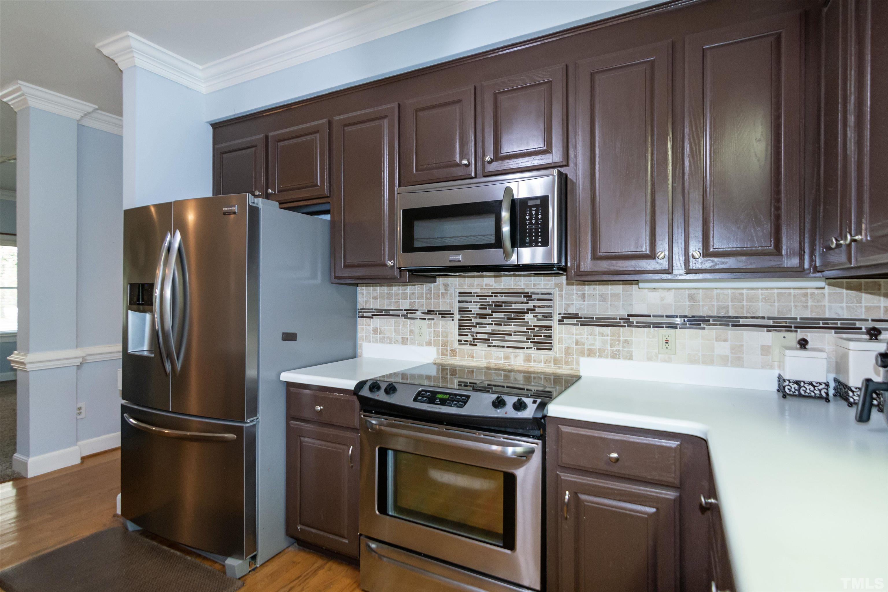 7020 Zebulon Road Wake Forest, NC 27587 - Photo 12 of 45 a kitchen with granite countertop a stove microwave and refrigerator