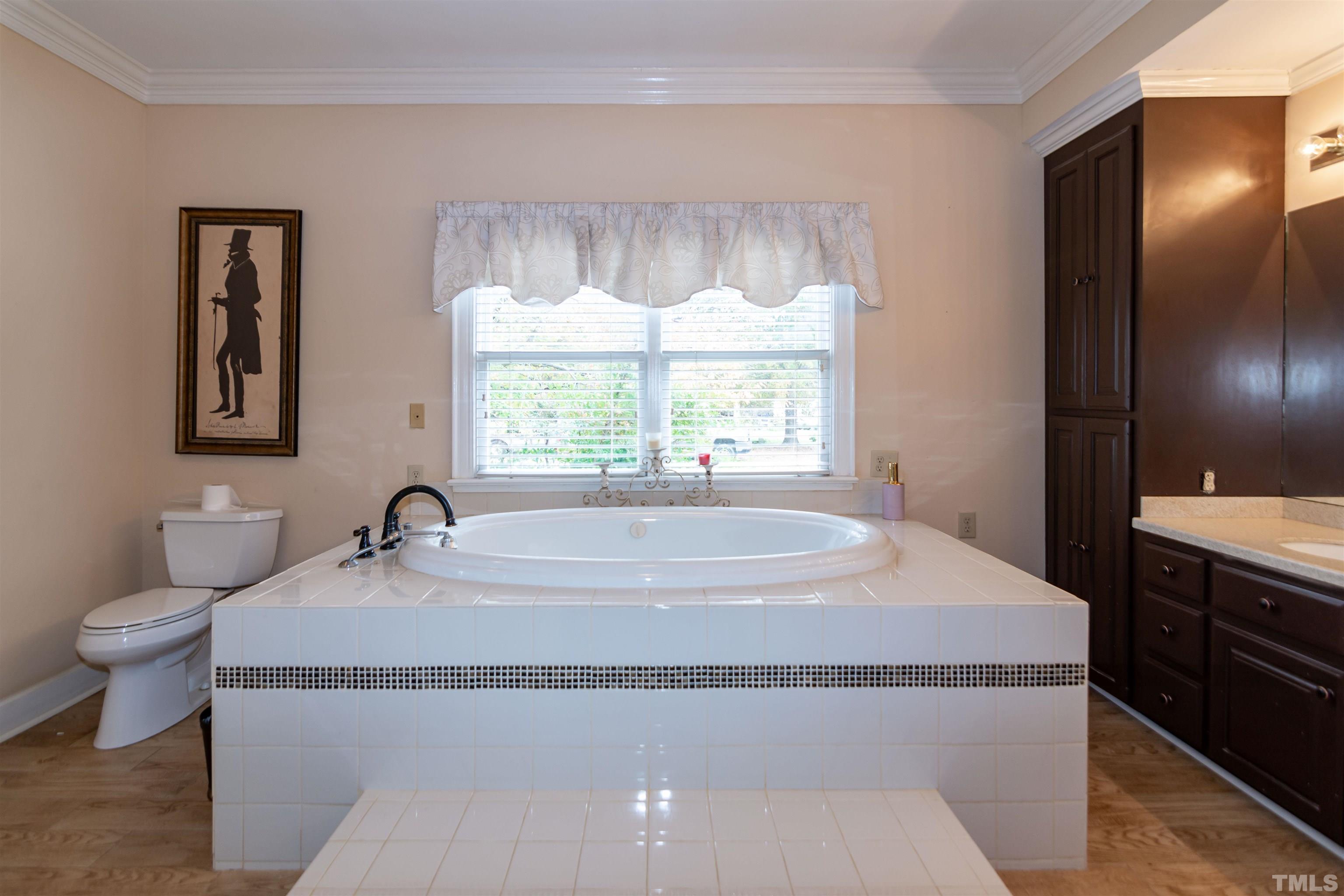7020 Zebulon Road Wake Forest, NC 27587 - Photo 16 of 45 a spacious bathroom with a granite countertop sink and a bathtub