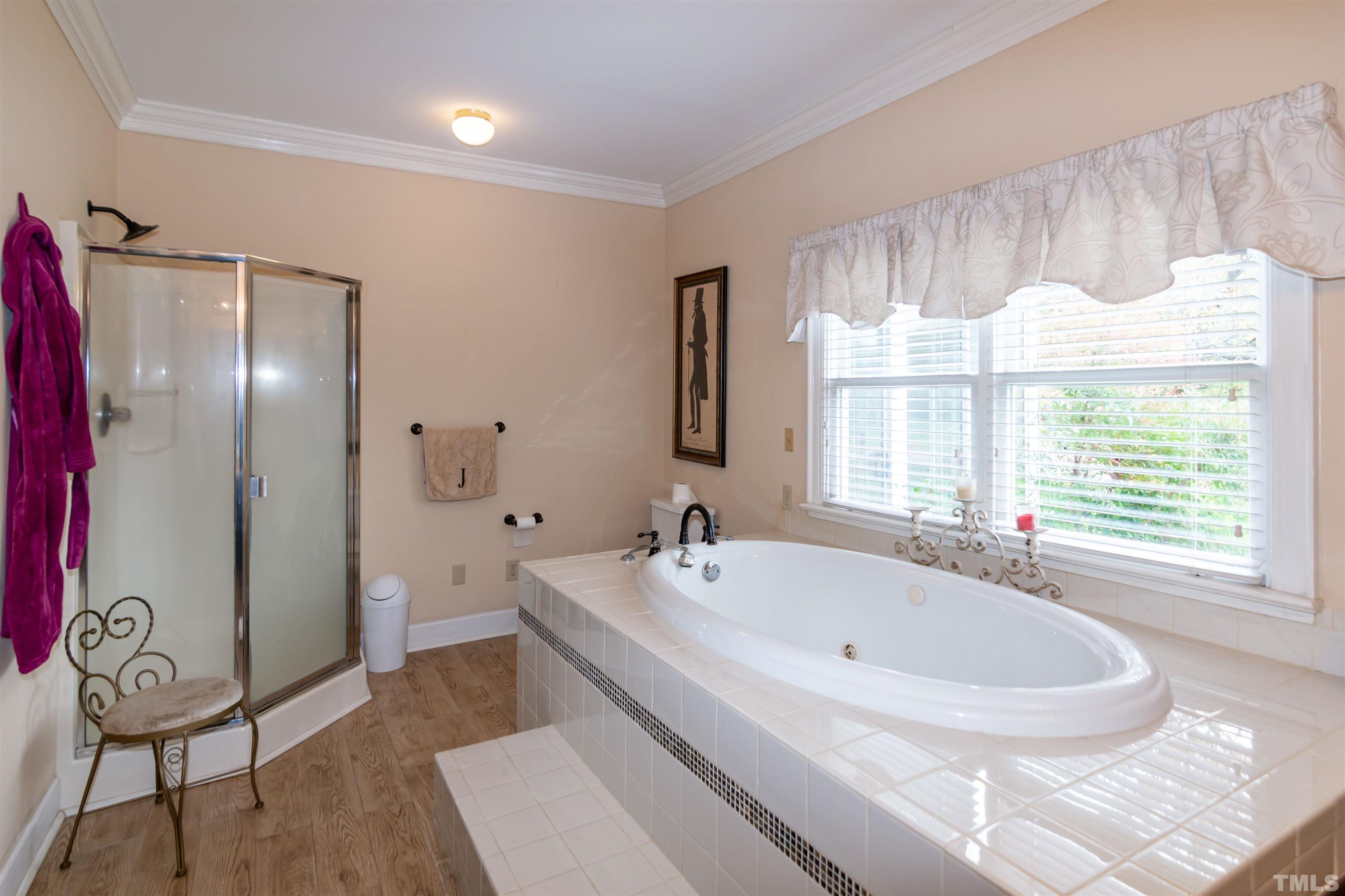 7020 Zebulon Road Wake Forest, NC 27587 - Photo 17 of 45 a white bath tub sitting in a spacious bathroom next to a window