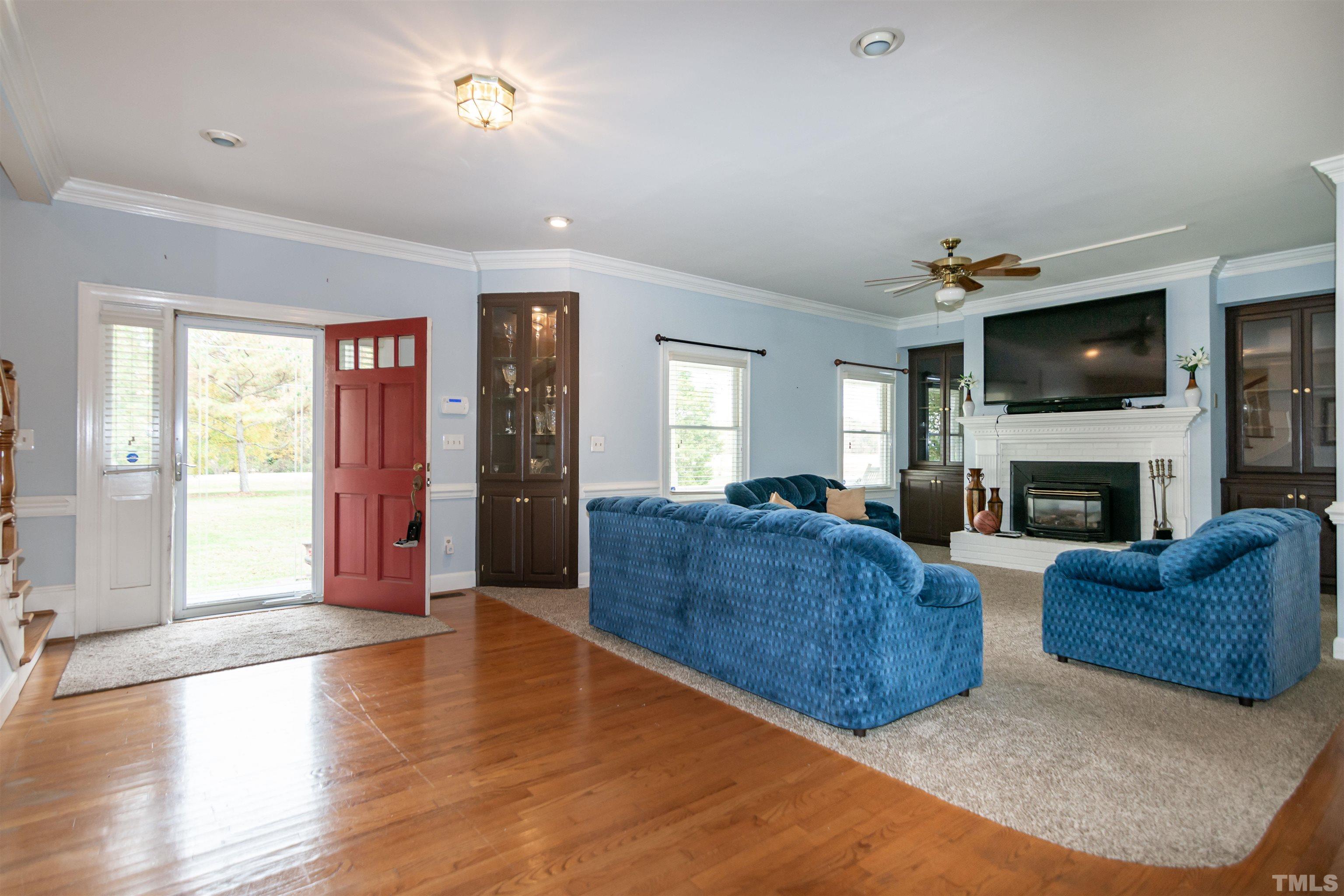 7020 Zebulon Road Wake Forest, NC 27587 - Photo 6 of 45 a living room with furniture a flat screen tv and a fireplace