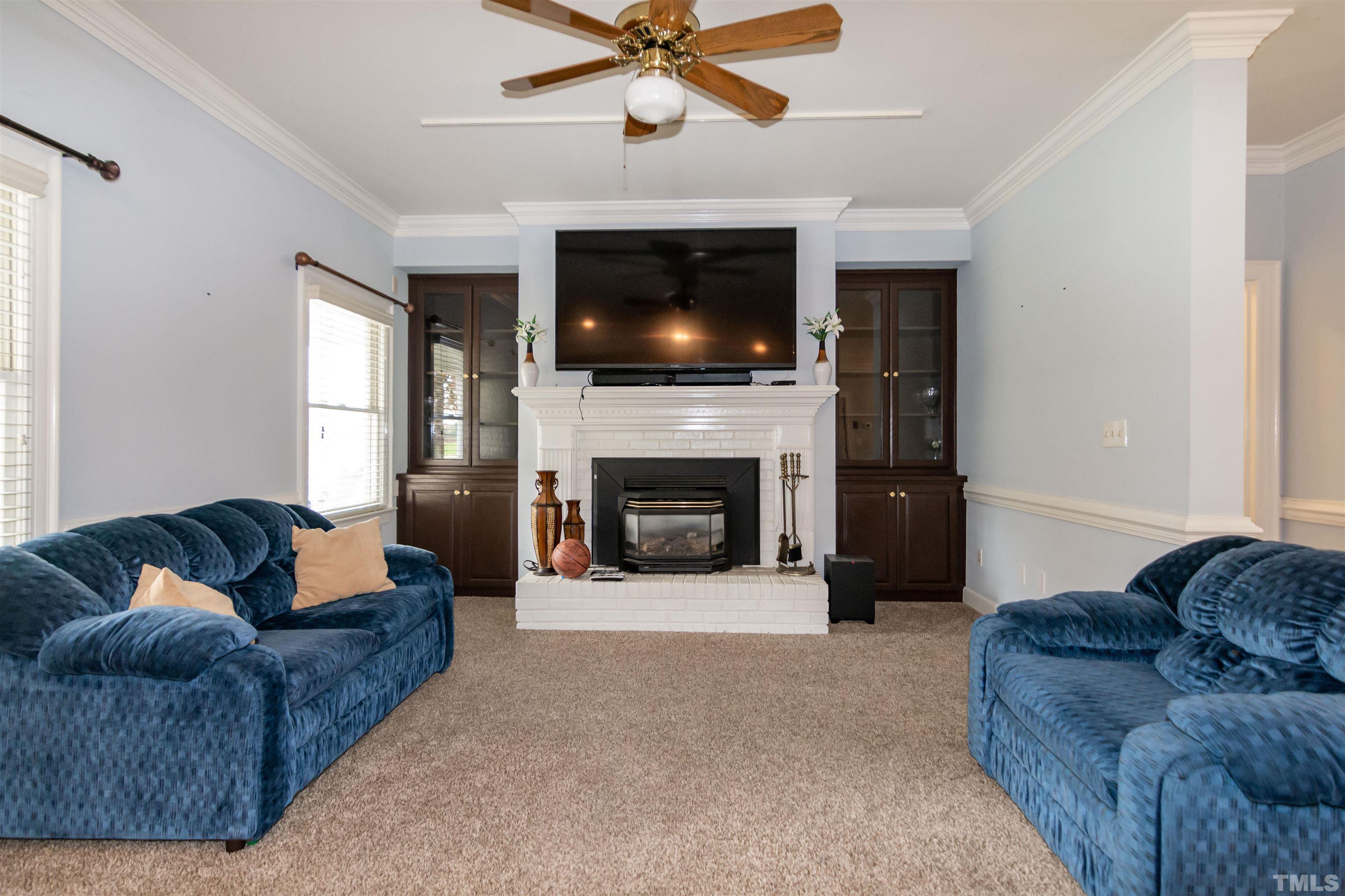 7020 Zebulon Road Wake Forest, NC 27587 - Photo 7 of 45 a living room with furniture a flat screen tv and a fireplace