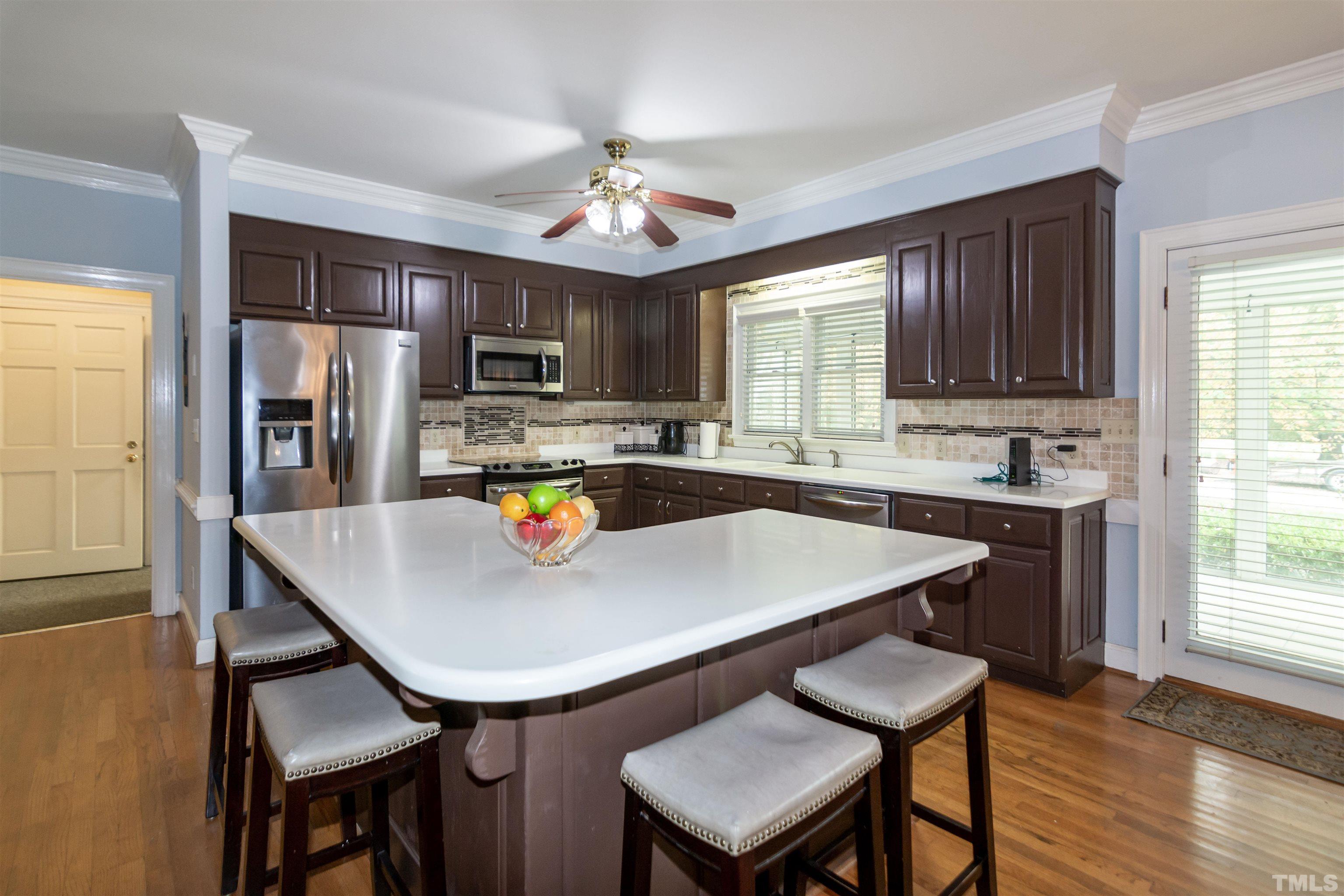 7020 Zebulon Road Wake Forest, NC 27587 - Photo 10 of 45 a kitchen with stainless steel appliances granite countertop a sink dishwasher a stove a refrigerator a microwave oven with a dining table and chairs