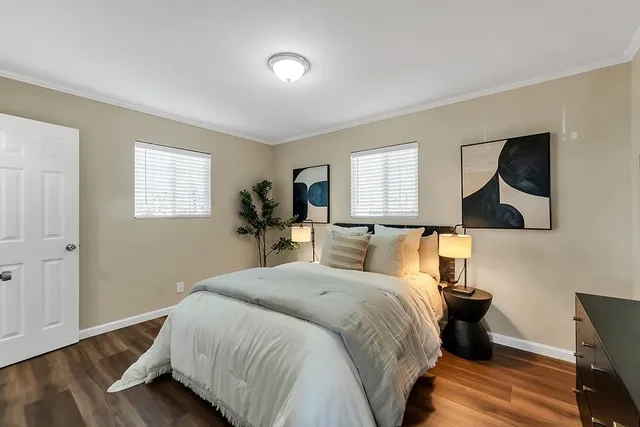a bedroom with a bed and wooden floor
