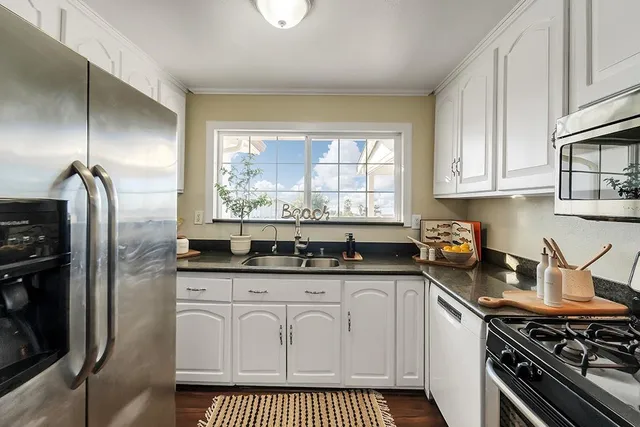 a kitchen with granite countertop a stove sink and refrigerator