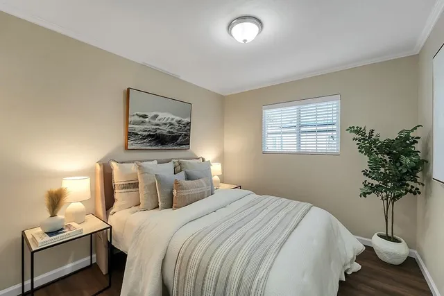a bedroom with bed and a potted plant