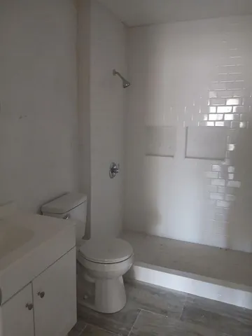 a white toilet sitting next to a bath tub