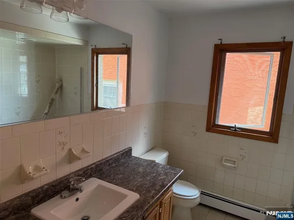 a bathroom with a sink a toilet and a window