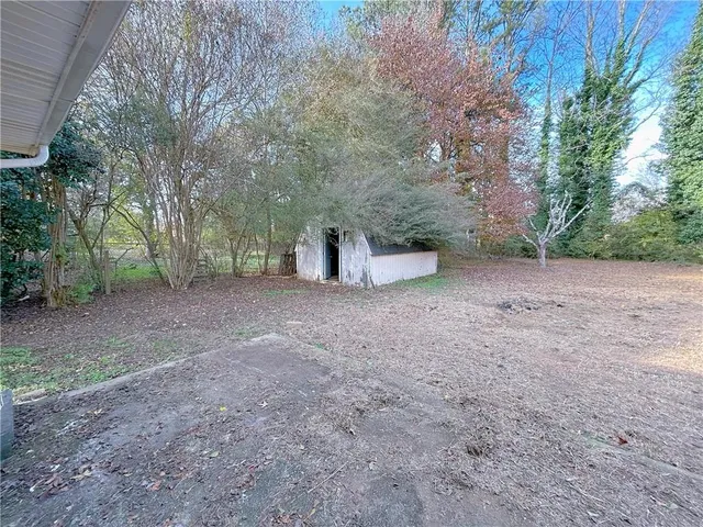 a view of a field with large trees