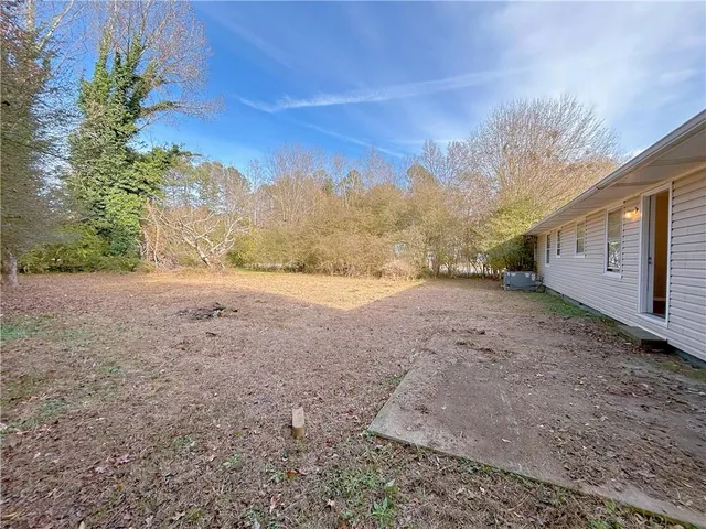 a view of a dry yard with trees