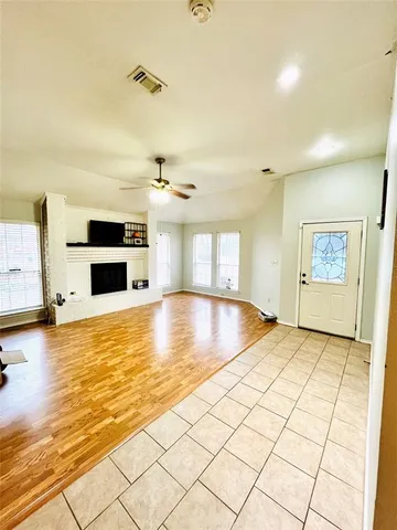 a view of kitchen and empty room with wooden floor