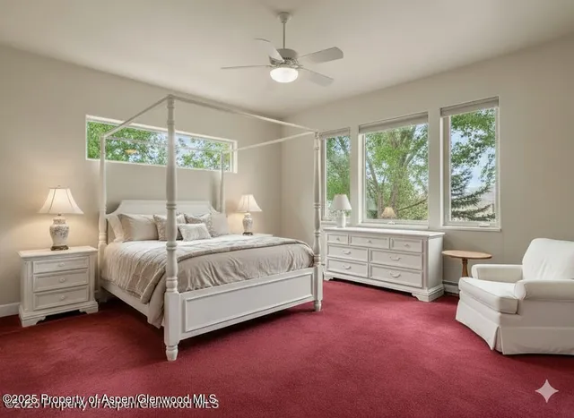 an empty room with windows and fireplace
