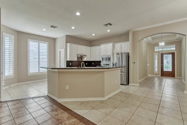 a kitchen with stainless steel appliances granite countertop a refrigerator a stove and a sink