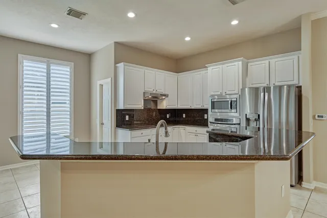 a kitchen with stainless steel appliances a sink a stove and cabinets